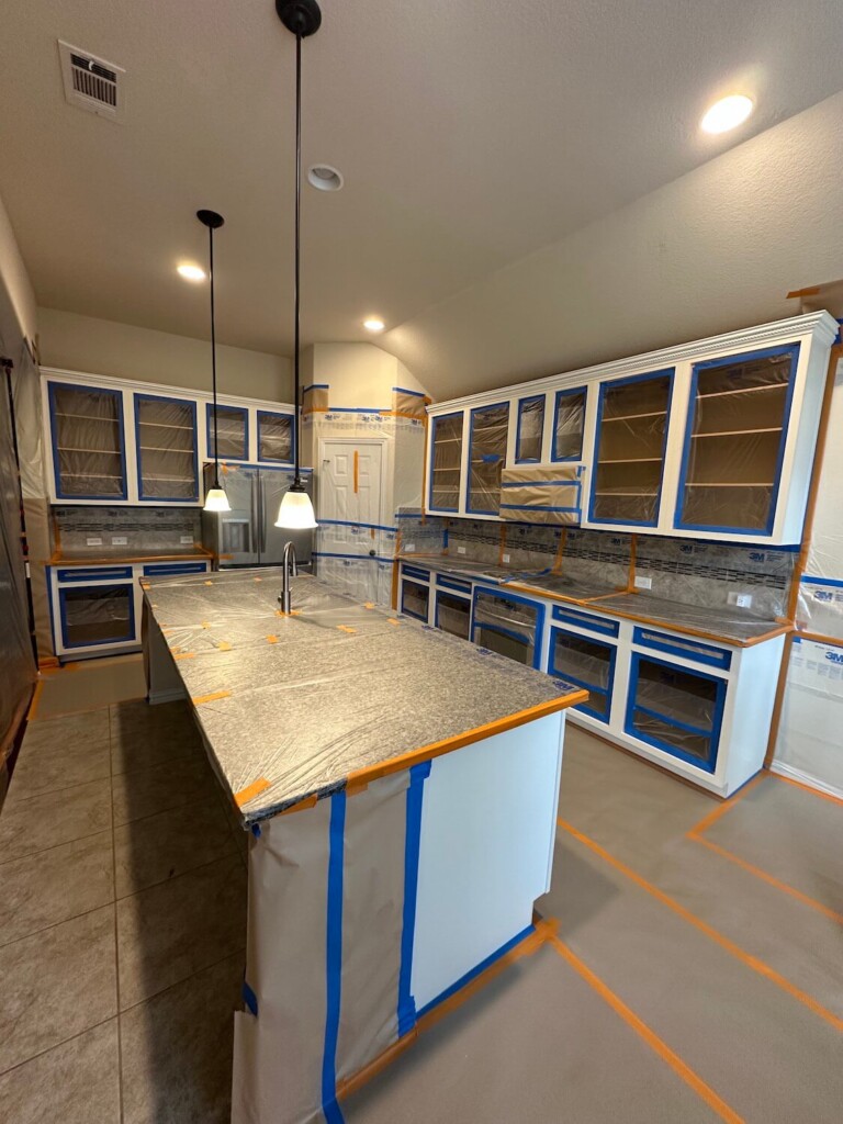 Cabinets masked off in plastic during finishing